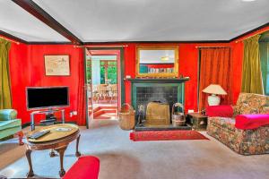 un soggiorno con pareti rosse e camino di Finest Retreats - The West Wing at The Mill House a East Linton