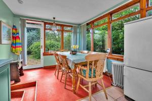 cocina con mesa, sillas y ventanas en Finest Retreats - The West Wing at The Mill House en East Linton