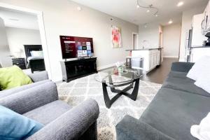 a living room with two couches and a glass table at 2BR 2BA Top Floor DT GR Penthouse Parking &Gym in Grand Rapids