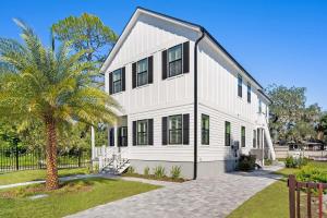 a white house with black windows and a palm tree at Lincolnville Luxe Upscale Home in Heart of St Aug in St. Augustine