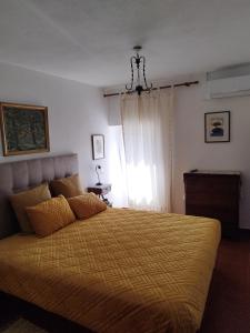 um quarto com uma cama com um edredão amarelo e uma janela em Casa da Fonte em Alviobeira
