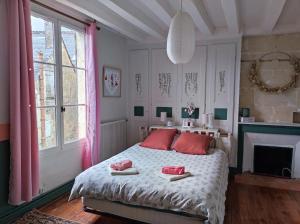 Un dormitorio con una cama con almohadas rojas. en Gîte de la vallée à Courdemanche Sarthe en Courdemanche