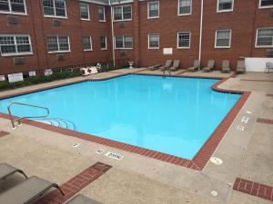 a large blue swimming pool in front of a building at 2BR and 2BA Beer City Flat with Pool Gym and Parking in Grand Rapids