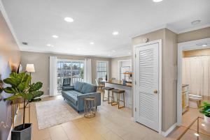a living room with a blue couch and a kitchen at Dog Friendly Condo Moon and Stars Walk to DT Patio in Saint Augustine
