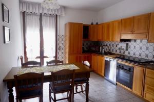 una cocina con armarios de madera y una mesa con sillas. en L'edera appartamento en Rivoli Veronese