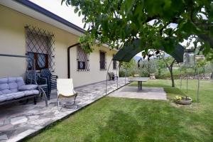 a patio with a couch and a table in a yard at L'edera appartamento in Rivoli Veronese