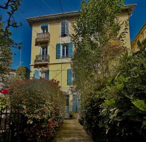 a yellow building with windows and bushes at Nice Liberation - Luxury & Design Apartment, 2 Private Rooms with 2 Private Bathroom for 2 or max 6 person, Renovated, Modern, AC, Wi-Fi, Balcony, Calm, Tram in Nice