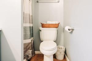 a bathroom with a toilet with a basket on top of it at Beach Club of Oscoda Captains Watch on the Lake in Oscoda