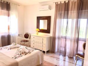 1 dormitorio con cama, tocador y espejo en Le Rose Suite Apartments, en Galatone