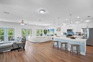 a large kitchen and living room with a table and chairs at Treetop Terrace 250 Steps to Beach Heated Swim Spa in Saint Augustine