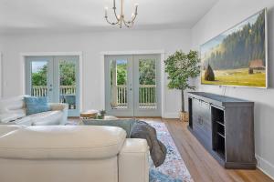 a living room with a white couch and a fireplace at Treetop Terrace 250 Steps to Beach Heated Swim Spa in Saint Augustine
