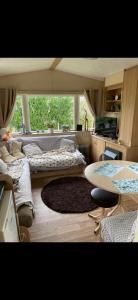 uma sala de estar com uma cama e uma mesa em 2-Bed Caravan in Mablethorpe sea front location em Mablethorpe