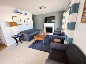 ein Wohnzimmer mit 2 blauen Sofas und einem Tisch in der Unterkunft Beach Club of Oscoda Beach House on Lake Huron in Oscoda