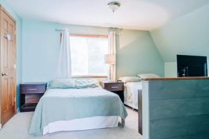 ein Schlafzimmer mit 2 Betten und einem TV in der Unterkunft Beach Club of Oscoda Beach House on Lake Huron in Oscoda