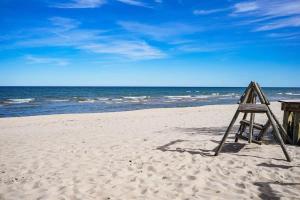 una scala di legno appoggiata su una spiaggia vicino all'oceano di Beach Club of Oscoda Garden Cottage on the Lake a Oscoda