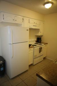 uma cozinha com armários brancos e um frigorífico branco em Apartment next to Fort Sill Entrance Gate em Lawton