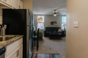 a kitchen with a refrigerator and a living room at Spacious 2BR Apt on Mass Ave w Kitchen in Indianapolis