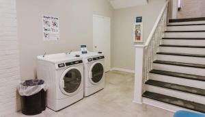 a laundry room with a washing machine and stairs at Spacious 2BR Apt on Mass Ave w Kitchen in Indianapolis