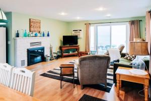 un soggiorno con divano e camino di Beach Club of Oscoda - The Lakeshore Cottage a Oscoda