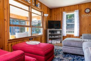 een woonkamer met een bank en een tv bij Priscilla's Place on Big Pine Island Lake in Belding