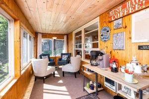 Zimmer mit Holzwänden und -stühlen sowie einer Küche in der Unterkunft Priscilla's Place on Big Pine Island Lake in Belding