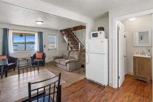 a kitchen and living room with a white refrigerator at Fife Lake Lodge Multi-level Suite with Lake Views in Fife Lake