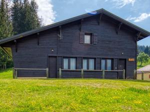 una grande casa nera con un prato davanti di Charmant chalet rénové, 10-12 pers, au pied des pistes à Morillon 1100 avec sauna et terrasse! - FR-1-642-5 a Morillon Altre 10 foto