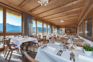 a restaurant with white tables and chairs and windows at Obergasserhof in Rodengo
