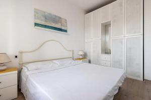a white bedroom with a white bed and white cabinets at [Seaside Apt] Private Parking and near the beach in Viareggio