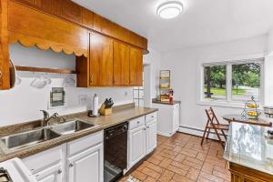 a kitchen with white cabinets and a sink at Charming 2BR Tudor-Style Apartment near MSU in East Lansing