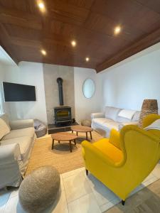 a living room with a yellow couch and a fireplace at Villa Blanche in Agon Coutainville