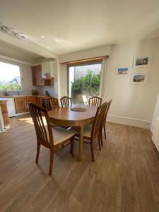 a kitchen and dining room with a wooden table and chairs at Villa Blanche in Agon Coutainville +14 photos