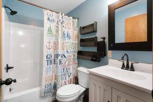 a bathroom with a toilet and a sink and a mirror at Fife Lake Lodge 2 Lakeside Apartment Units in One in Fife Lake +37 photos