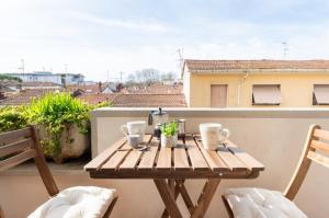 a wooden table on a balcony with a view of a building at [Seaside Apt] Private Parking and near the beach in Viareggio