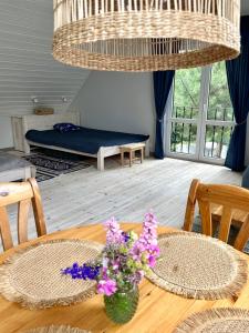 a room with a table with purple flowers on it at Leniwa Kolonia in Sarnaki +50 photos