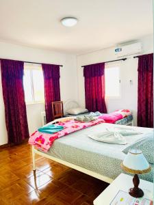 two beds in a bedroom with red curtains at Casa BB&Djassi in Ponta do Sol