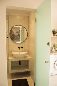 a bathroom with a sink and a mirror at Aristidis Apartments in Agios Georgios