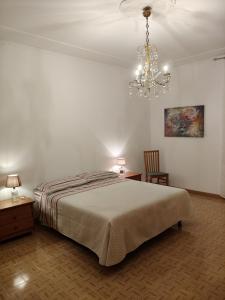 a bedroom with a bed and a chandelier at La Residenza del Cavallino in Fermo