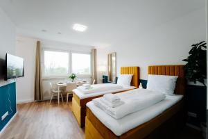 2 letti in una camera con tavolo e finestra di Jenapartments for4 Boxspring & Smart TV & Waschmaschine a Jena