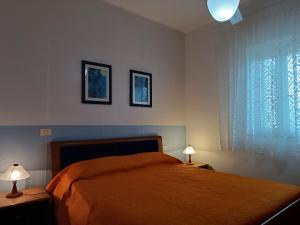 a bedroom with a bed with two lamps and a window at VILLETTE FABRIZIO, 2023 a VIESTE in Vieste