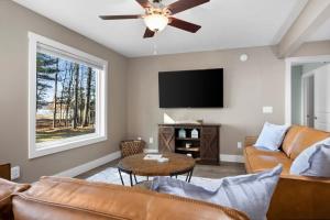 a living room with a couch and a flat screen tv at Long Lake Dream Dogs Welcome in Traverse City
