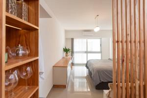 a bedroom with a bed and a desk and a window at Museo Paseo de la Cisterna, UF 431 in Buenos Aires +21 photos