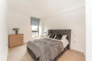 2 bed apartment near Little Britain Lake في أوكسبريدج: غرفة نوم بيضاء مع سرير كبير ونافذة