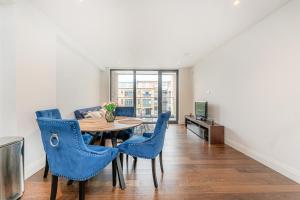 2 bed apartment near Little Britain Lake في أوكسبريدج: غرفة طعام مع طاولة وكراسي زرقاء
