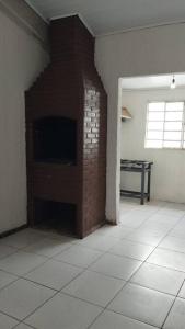 a room with a brick wall with a tv in it at Casa de Festa in Uberaba