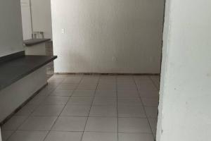 an empty room with a tile floor and a white wall at Casa de Festa in Uberaba