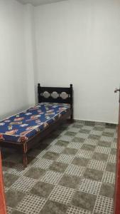 a bed sitting in a room with a tile floor at Casa de Festa in Uberaba