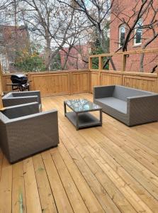 un patio con 2 sofás y una mesa en una terraza de madera en Heritage home in prime Byward Market location en Ottawa