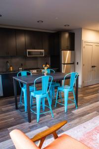 cocina con mesa y sillas azules en Modern State Unit 2, en Traverse City