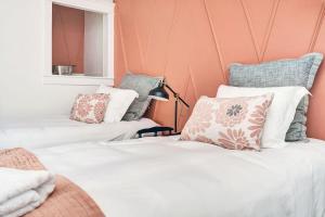 2 camas en una habitación con paredes y almohadas rosas en The Crick in PEC - 5 min walk to Main St, en Picton